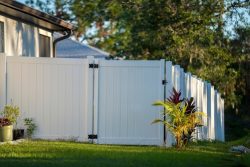 White,Vinyl,Picket,Fence,On,Green,Lawn,Surrounding,Property,Grounds